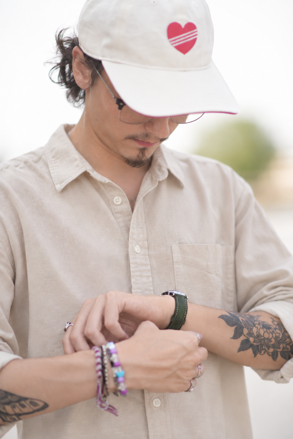 Homme portant une chemise beige regardant une montre Ternum à bracelet en cuir vert.